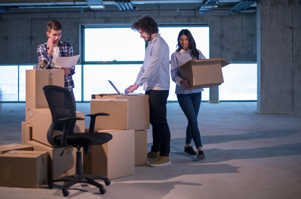 trois personnes qui déménagent des cartons